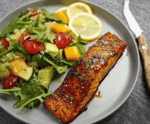 Delicious brown sugar glazed salmon fillet garnished with fresh herbs on a white plate, highlighting a sweet and savory seafood dish.