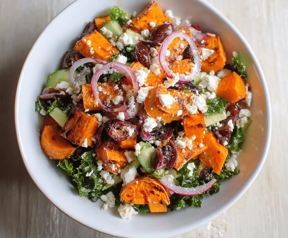 Colorful sweet potato Greek salad with fresh vegetables, feta cheese, and herbs in a bowl, perfect for a healthy, flavorful meal.
