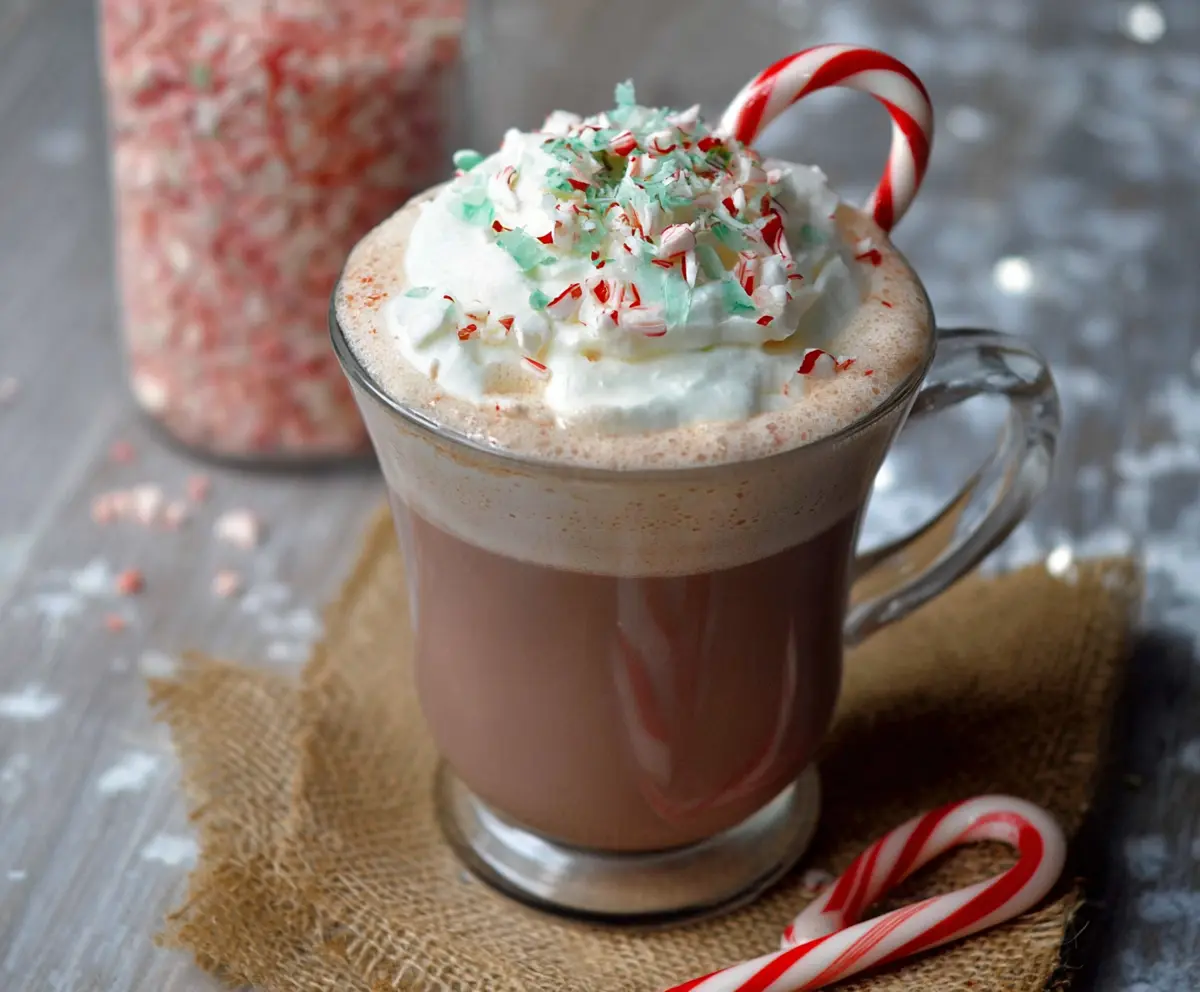Delicious Candy Cane Hot Chocolate topped with whipped cream and a candy cane stirrer