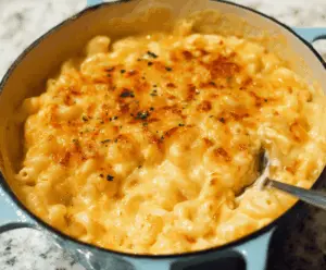 Creamy Paula Deen's Mac And Cheese served in a rustic bowl, topped with melted cheese and herbs