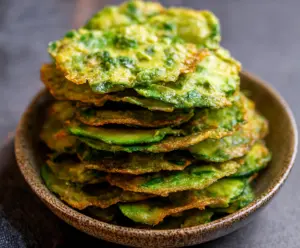 Crispy homemade avocado chips arranged on a wooden platter, perfect for healthy snacking.