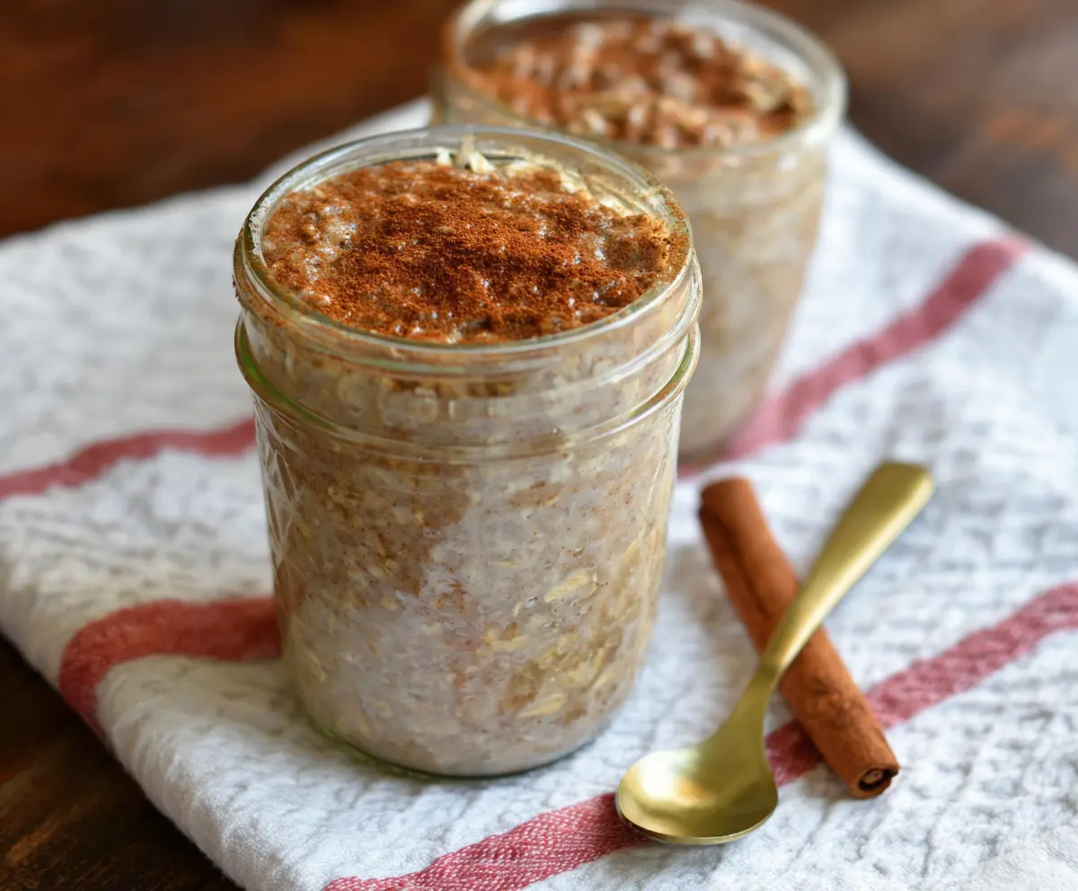 Delicious Snickerdoodle Overnight Oats topped with cinnamon and sugar, served in a glass jar.