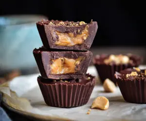Delicious Snickers Cups with peanut butter, caramel, and chocolate topping for dessert lovers.