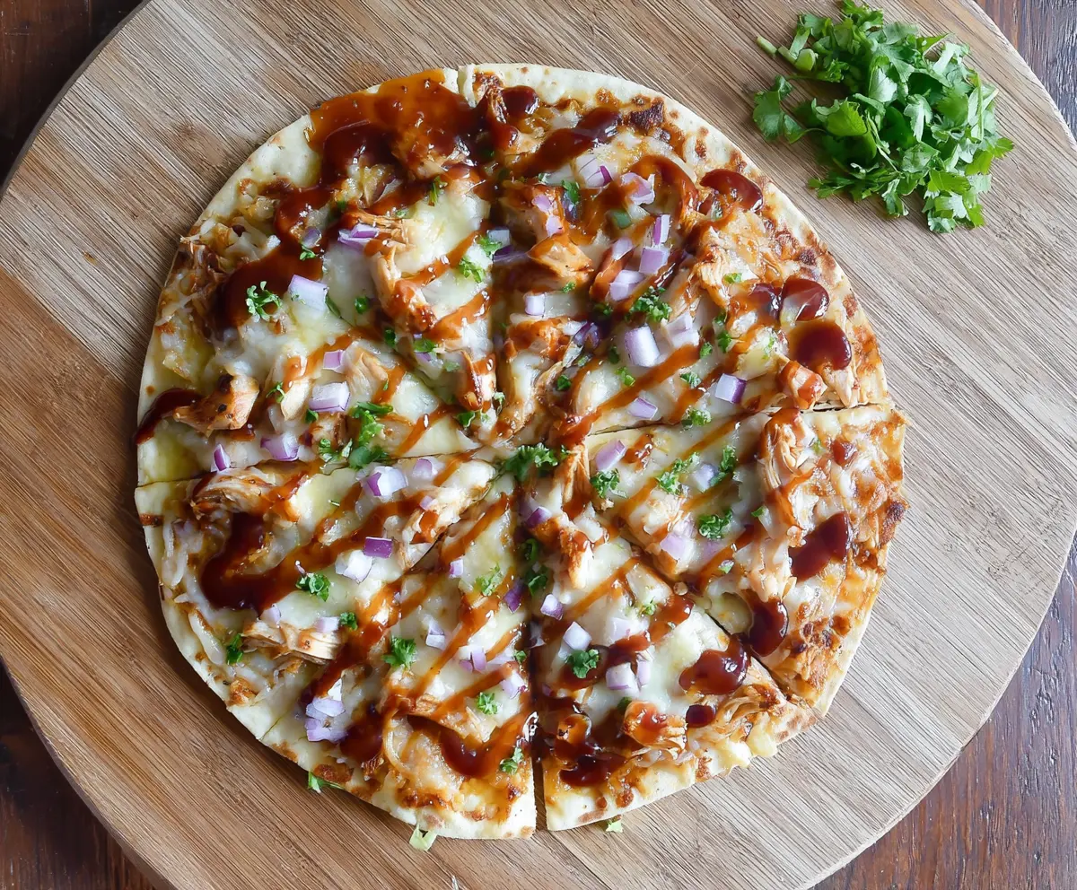 Delicious BBQ Chicken Tortilla Pizza with melted cheese and grilled chicken on a crispy tortilla base.