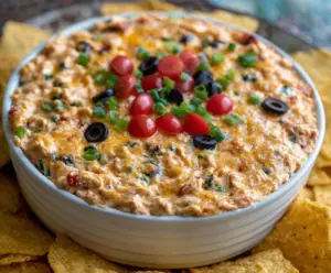 Delicious Chicken Taco Dip with melted cheese, fresh tomatoes, and seasoned chicken served as a tasty appetizer.