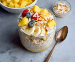 Creamy pineapple overnight oats in a jar topped with fresh pineapple chunks and chia seeds.