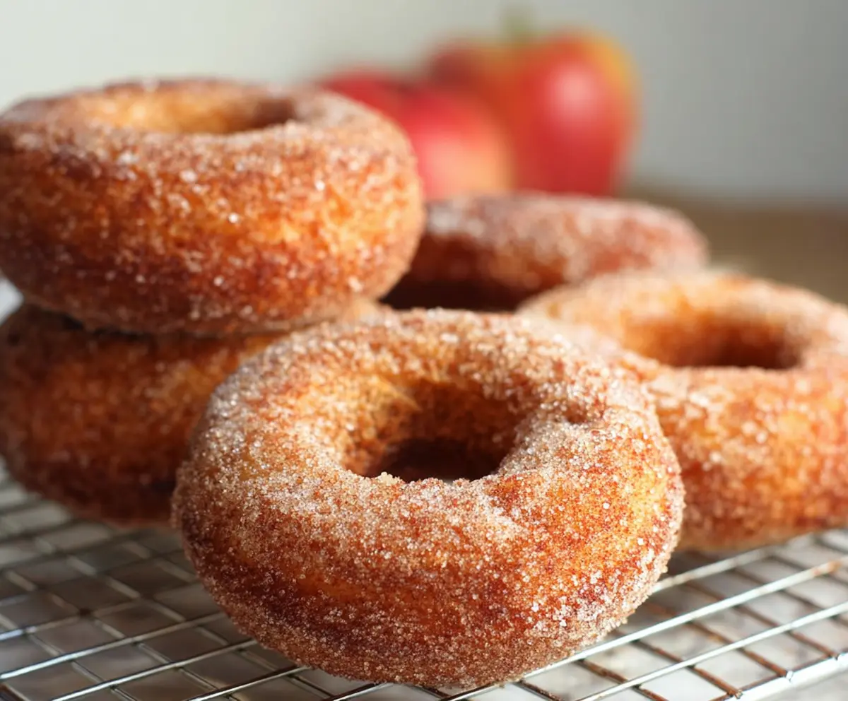 Freshly baked sourdough discard apple cider donuts bread on a rustic wooden surface.