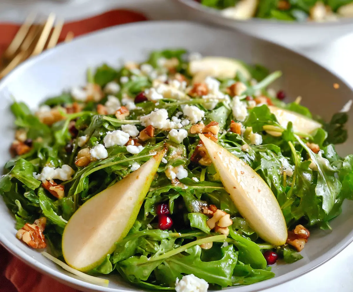 Fresh arugula and juicy pear salad served with walnuts and feta cheese, perfect for a healthy meal.