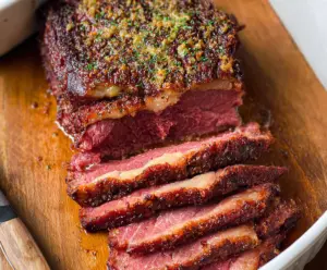 Delicious baked corned beef served with vegetables and potatoes, perfect for a hearty meal.