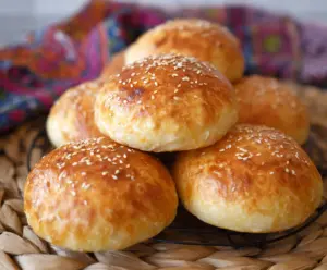 Golden baked cottage cheese buns on a rustic wooden table, perfect for breakfast or snacks.