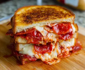 Delicious pepperoni pizza grilled cheese sandwich with melted cheese and crispy bread.