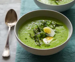 Fresh Primavera Spring Green Soup in a bowl with vibrant vegetables and herbs for a healthy meal.