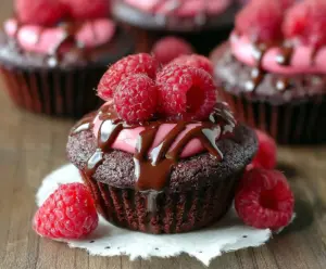 Delicious raspberry chocolate lava cupcake with gooey center and fresh raspberries on top.
