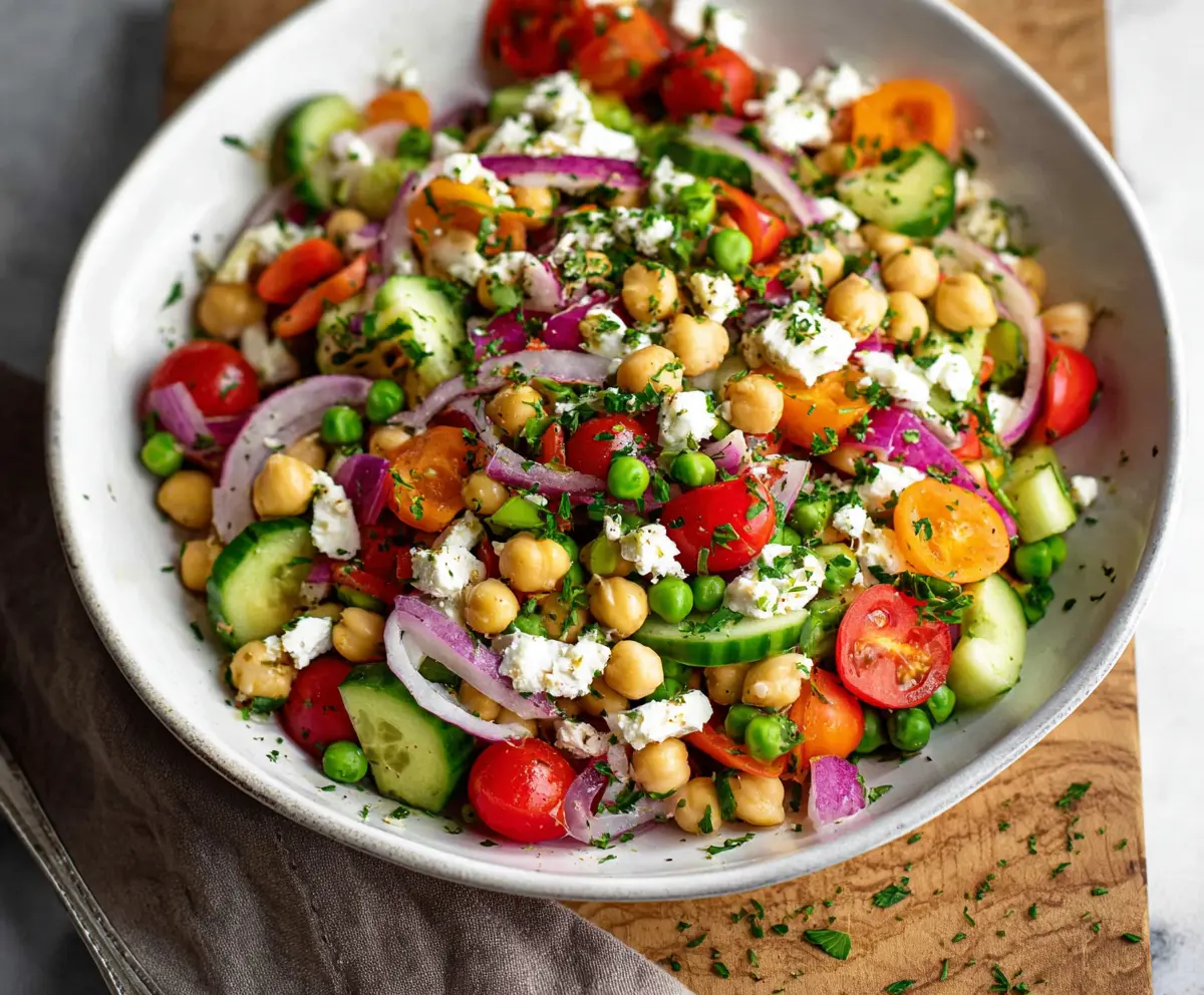 Fresh Mediterranean Pea Salad with cucumbers, tomatoes, and feta cheese in a vibrant bowl.