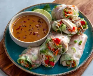 Delicious pork spring rolls with fresh vegetables served with creamy peanut lime sauce.