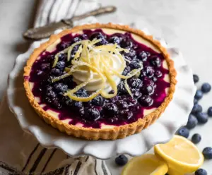 Delicious Lemon Blueberry Tart garnished with fresh blueberries and lemon slices, perfect for summer desserts.